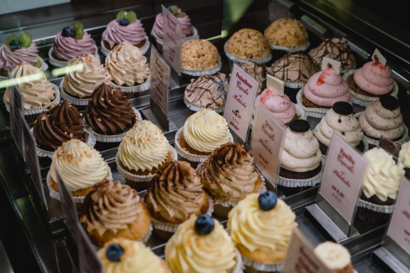 Cupcakes Wien: mehrere Cupcakes in verschiedenen Farben in einer Vitrine